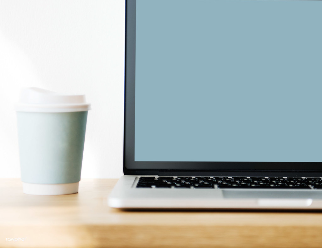 Coffee cup and notebook on a wooden table