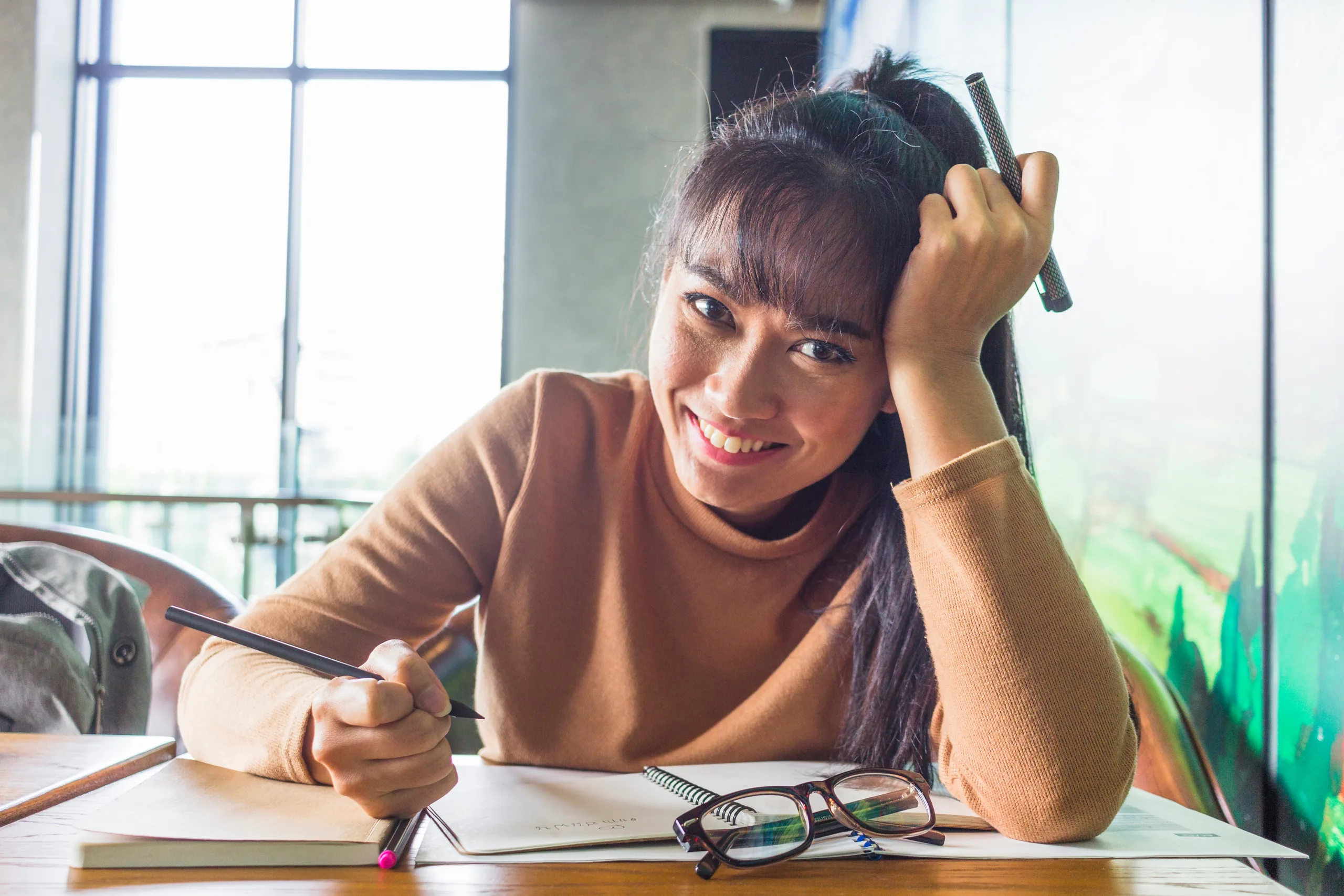 A student writing by hand in a notebook during a language class.
