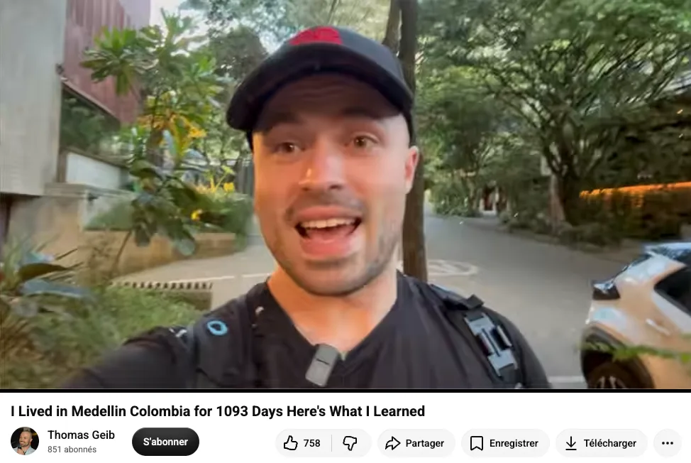 Young man in a black cap and backpack recording a selfie on a tree-lined Medellín street; thumbnail of the video I Lived in Medellin Colombia for 1093 Days