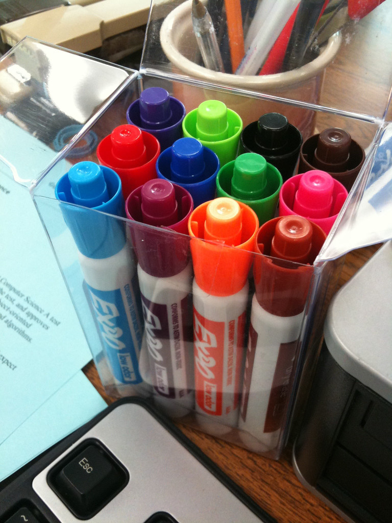 Colored markers next to a whiteboard